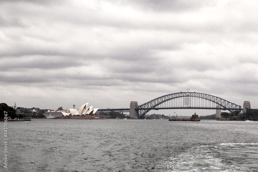 Skyline von Sydney mit Opera House und Harbour Bridge an einem bewölkten Tag.