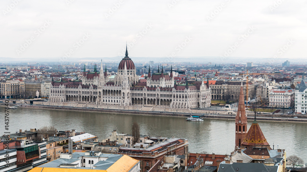 Obraz premium Cityscape of Budapest with hungarian parliament building on Danube river seen from the Buda side on a cloudy day