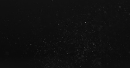 dust particles fast moving over black background from right, 4k photo
