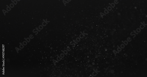 dust particles fast moving over black background from right, 4k photo
