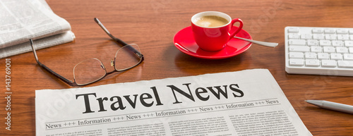 A newspaper on a wooden desk - Travel News
