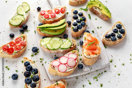 Homemade summer toast with cream cheese Smoked Salmon, Blueberries, Radish, Cucumber, Avocado and cress salad. Fresh healthy concept food.