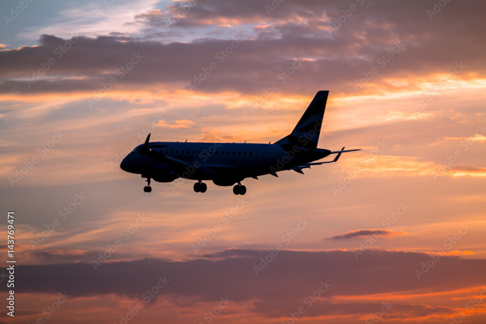 Airplane landing at sunset Airplane landing at sunset