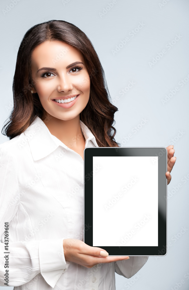 Businesswoman showing blank tablet pc, on grey Businesswoman showing blank tablet pc, on grey