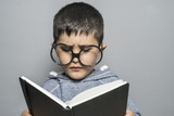 Read, Boy with giant glasses reading a book with funny and varied gestures