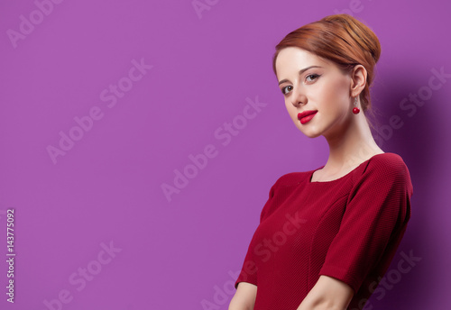 photo of beautiful young woman standing on the wonderful purple studio background