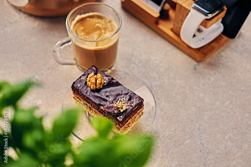 Sweet, delicious cake, herbs and cop of coffee on a table.