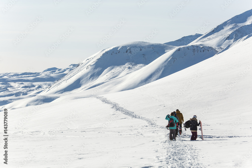 Skiers walk on the frozen trail. Beautiful winter landscape with snow-topped mountains. Ski resort