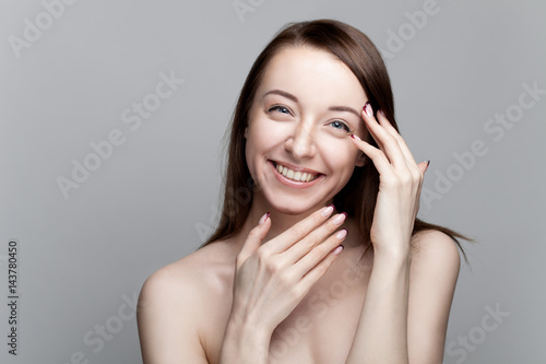 Isolated on gray background studio portrait of young brunette with manicure on nails