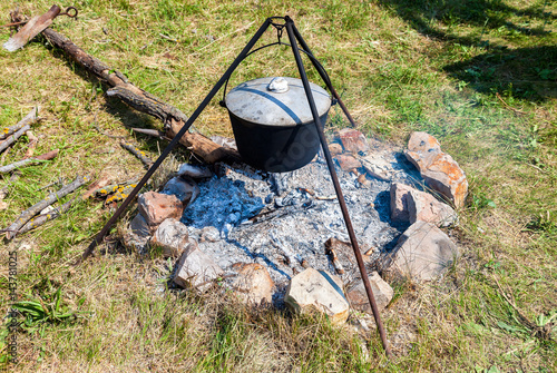 Cooking food on a camp fire outdoors in summer sunny day