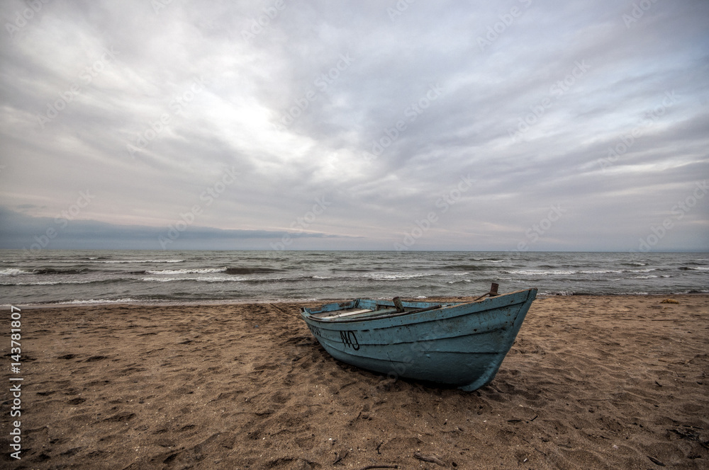 Beautiful landscape of Boat on the beach in cloudy weather. Vintage Boat in the seashore. Azerbaijan Caspian Sea Novkhani