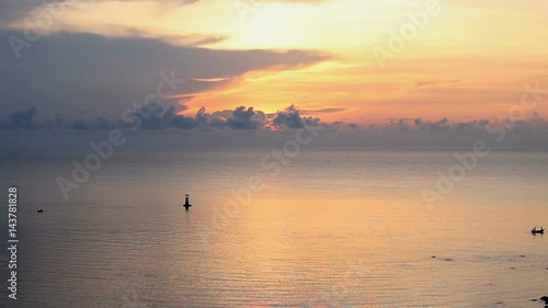 silhouette sunrise over sea with lighthouse and local fishery boat