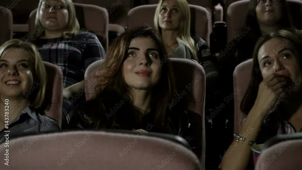 Movie theater. Three pretty female friends watching a movie in the cinema. HD Movie theater. Three pretty female friends watching a movie in the cinema. HD