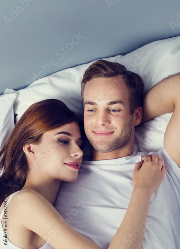 Happy young couple on the bed