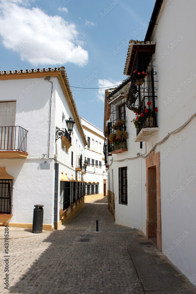 Spain. Andalucia. Ronda. Street of town with white houses, vertical view.