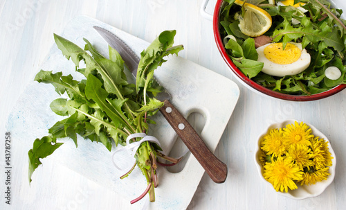 Fototapeta Naklejka Na Ścianę i Meble -  Dandelion leaves bouquet on cutting board