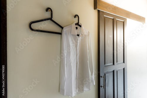 Men s white shirt hanging at the wall with sun flare