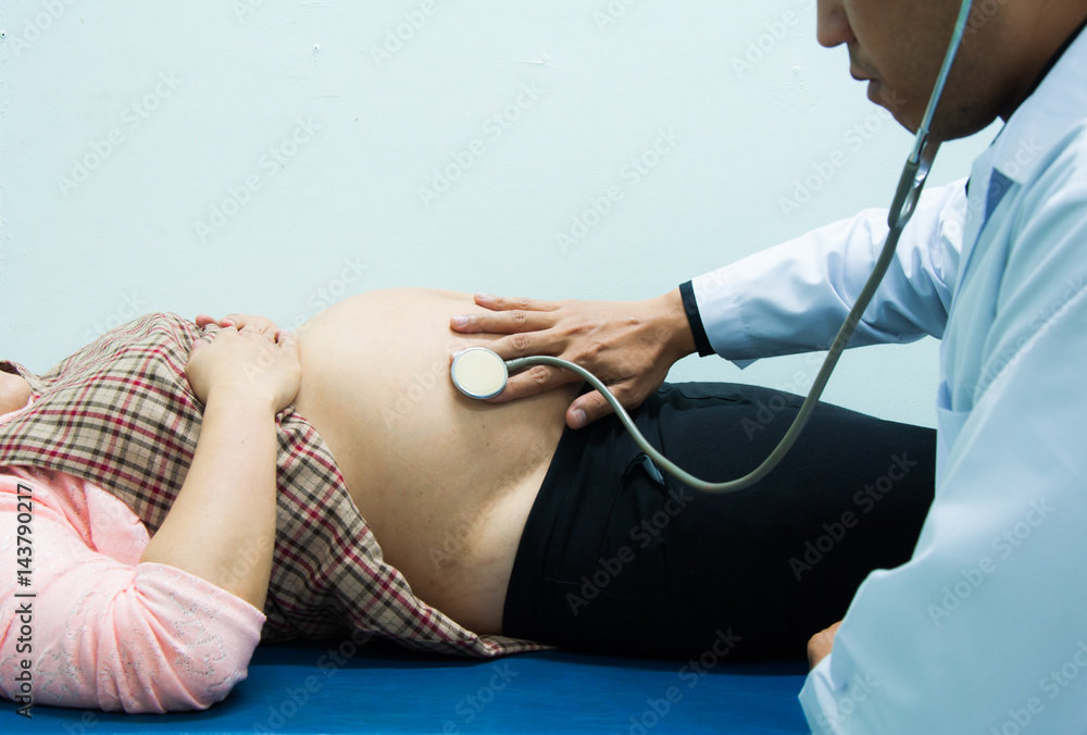 Doctor using stethoscope examining pregnant woman in the hospital