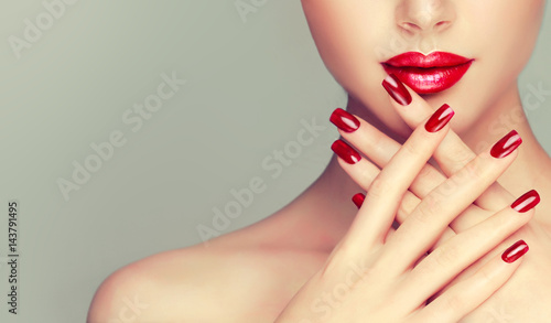 Fényképezés Beautiful girl showing red  manicure nails . makeup and cosmetics