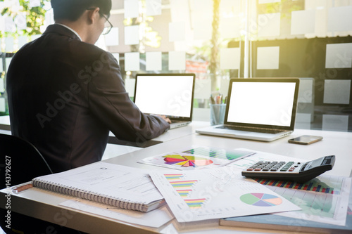 Image of young businessmen using laptop with many document graph at office in the morning photo