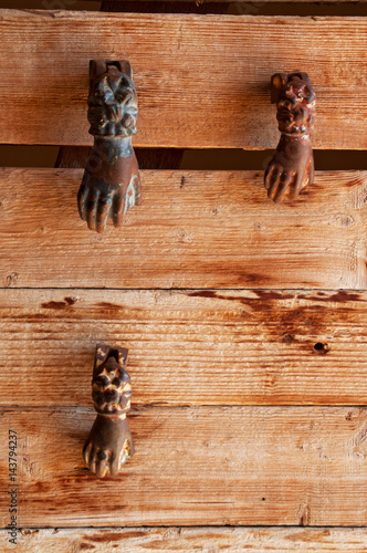 Decorazioni vintage per la casa: dettaglio di una porta di legno con tre battenti a forma di mano photo