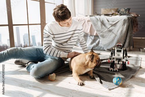 Scared dog staring at robot of his master