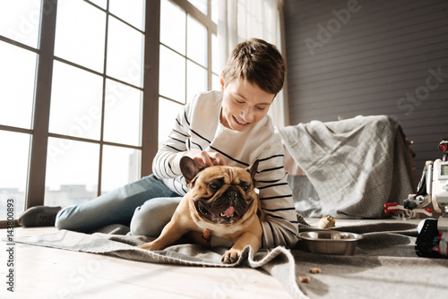 Smiling boy scratching head of his pet