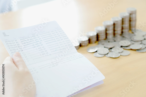 Fotografia Woman hold passbook on hand, coins background