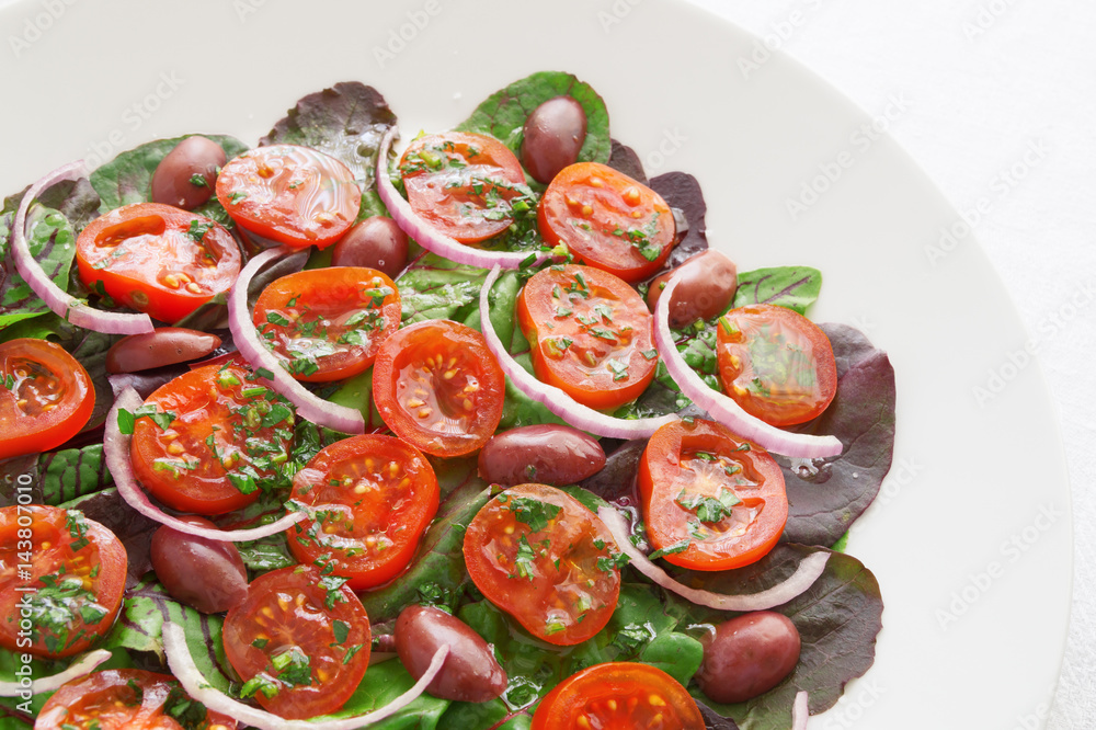 green salad with tomatoes, olives, and red onion dressed with olive oil and lemon juice green salad with tomatoes, olives, and red onion dressed with olive oil and lemon juice