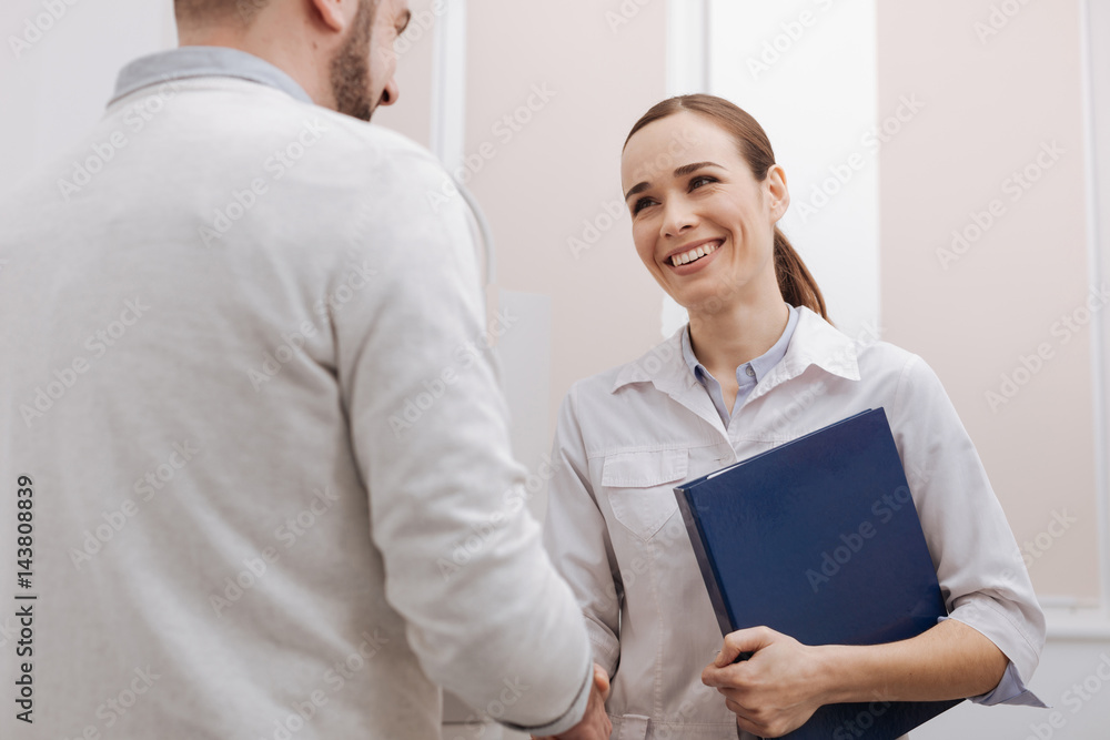 Happy delighted ophthalmologist greeting her patient Happy delighted ophthalmologist greeting her patient