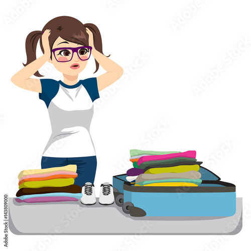 Desperate young woman packing overfilled suitcase with clothing