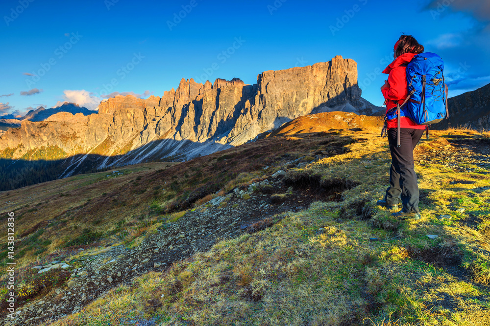 Sporty hiker woman with backpack on top of a mountain