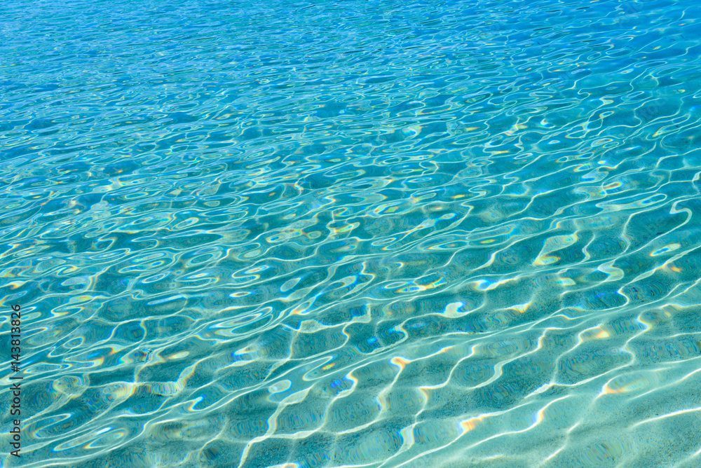 Shining blue water ripple background. Clear sea water background. Photo from Kalamitsi, Sitonia, Halkidiki, Macedonia, Northern Greece.
