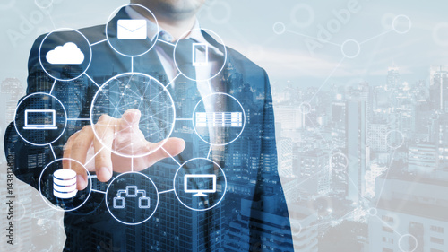 Double exposure of businessman connected devices with internet and wireless network on touch screen and city of business background in business and technology concept photo
