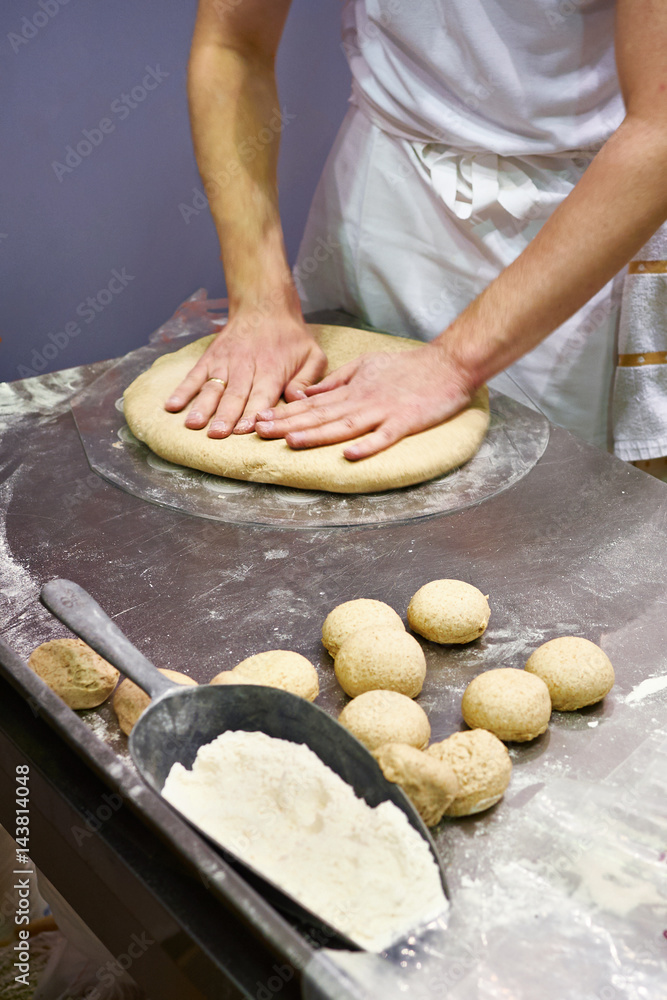 Cook prepares the dough for bun before baking