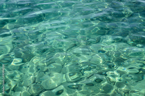 Obraz na płótnie Clear sea water background. Shining blue water ripple background. w salonie