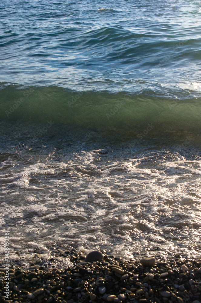 sea pebble beach with multicoloured stones, waves with foam sea pebble beach with multicoloured stones, waves with foam