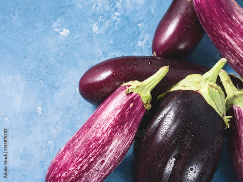 Purple eggplants on blue textured background. Healthy organice produce