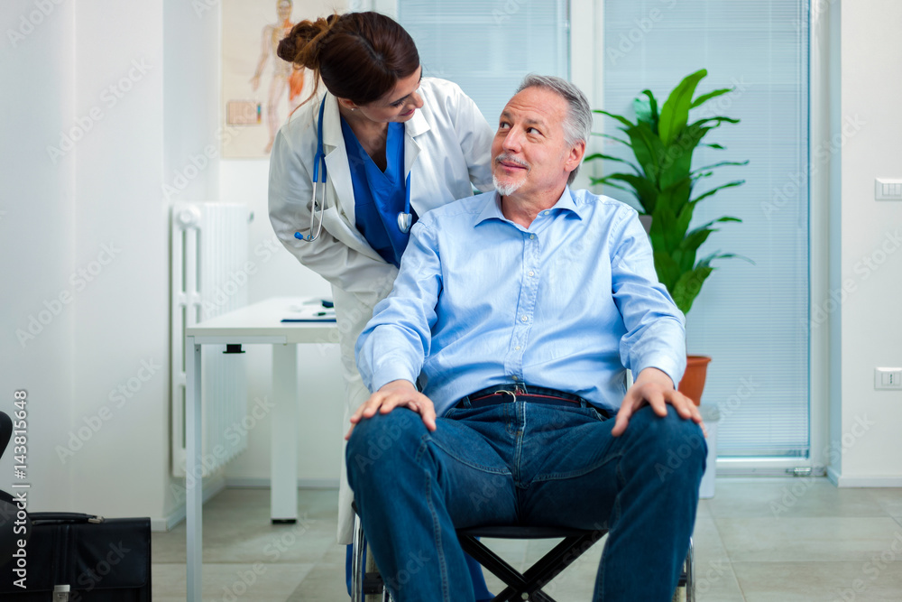 Female doctor talking to a patient on a wheelchair