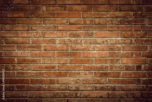 Old brick wall with cracks and scratches. Horizontal wide brickwall background. Distressed wall with broken bricks texture. Vintage house facade.
