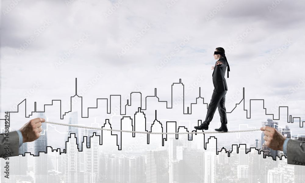 Business concept of risk support and assistance with man balancing on rope Business concept of risk support and assistance with man balancing on rope