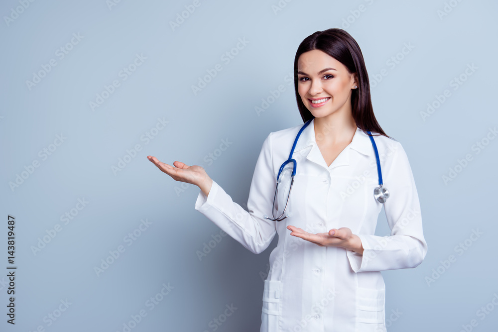Friendly smiling young female doctor demonstrate something healthcare product Friendly smiling young female doctor demonstrate something healthcare product