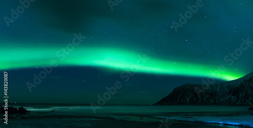 Aurora Borealis Known as Norther Lights Playing with Vivid Colors Over Lofoten Islands in Norway. © danmorgan12