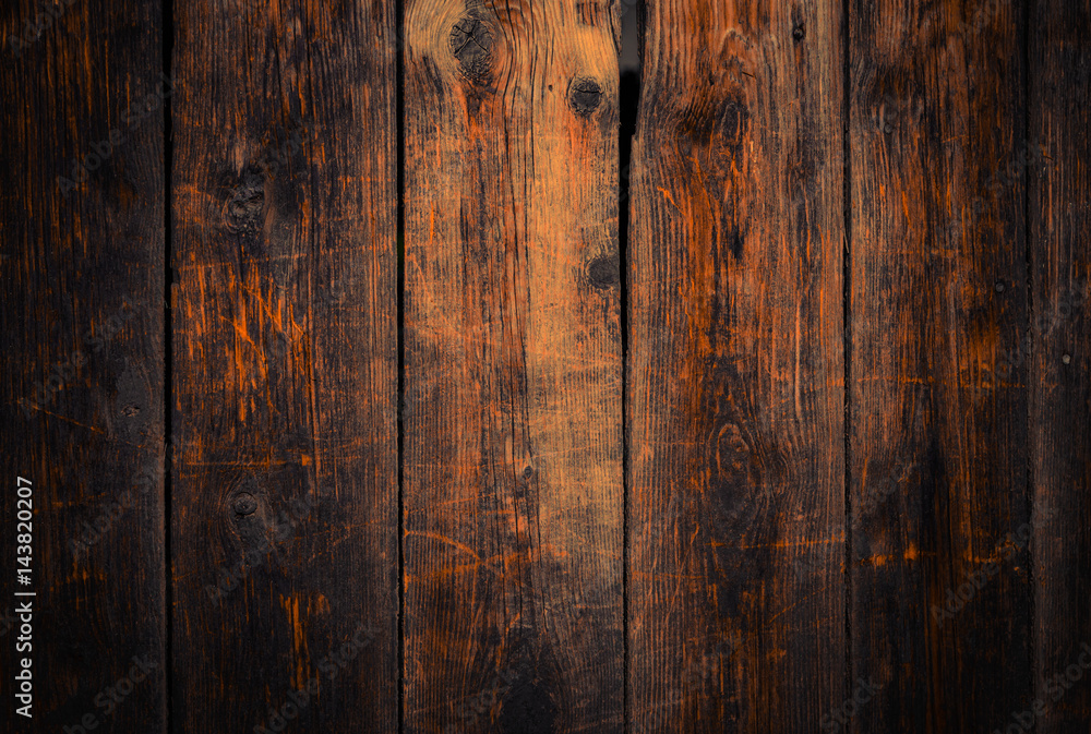 Old rural wooden wall in dark brown and orange colors, detailed plank photo texture. Natural wooden building structure background.
