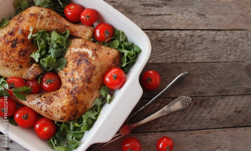 Baked chicken quarter with cherry tomatoes. Roast chicken quarter with the addition of cherry tomatoes. Selective focus