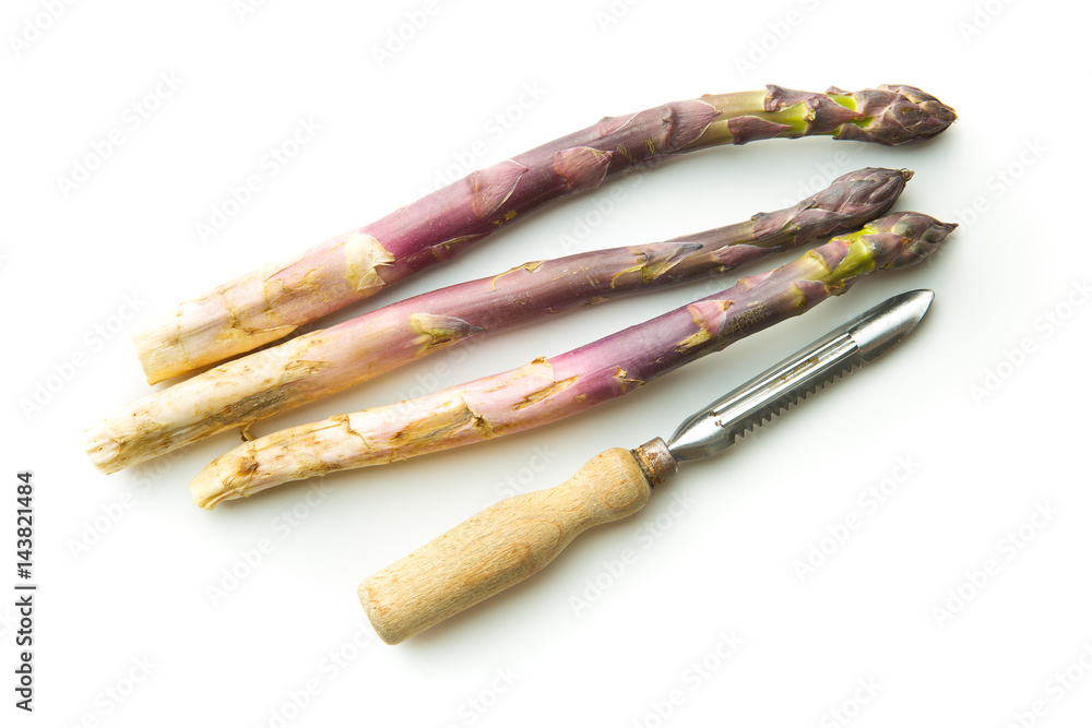 Fototapeta premium Fresh purple asparagus with peeler.