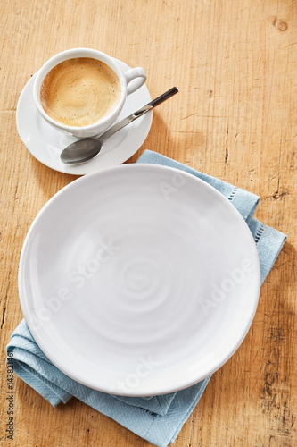 Plate and cup of coffee on table photo