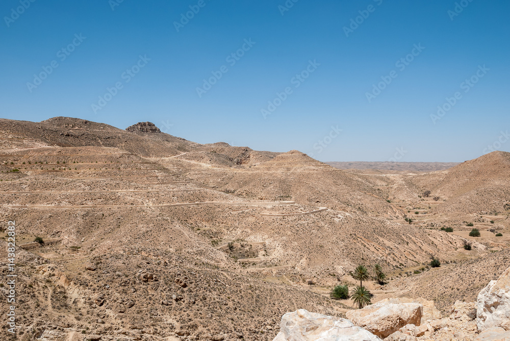 Mountains in the desert with the remains of old stone walls