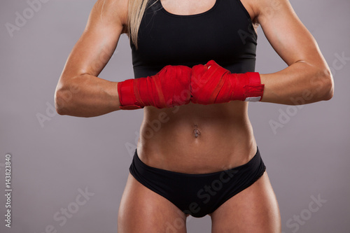 Close view of athletic girl posing in red bandages, isolated on the grey background boxing fighter kickbox © satyrenko