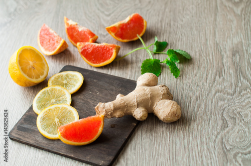 Ginger and lemon, spices and ingredients for drinks. Red oranges, citrus fruits on a wooden background.